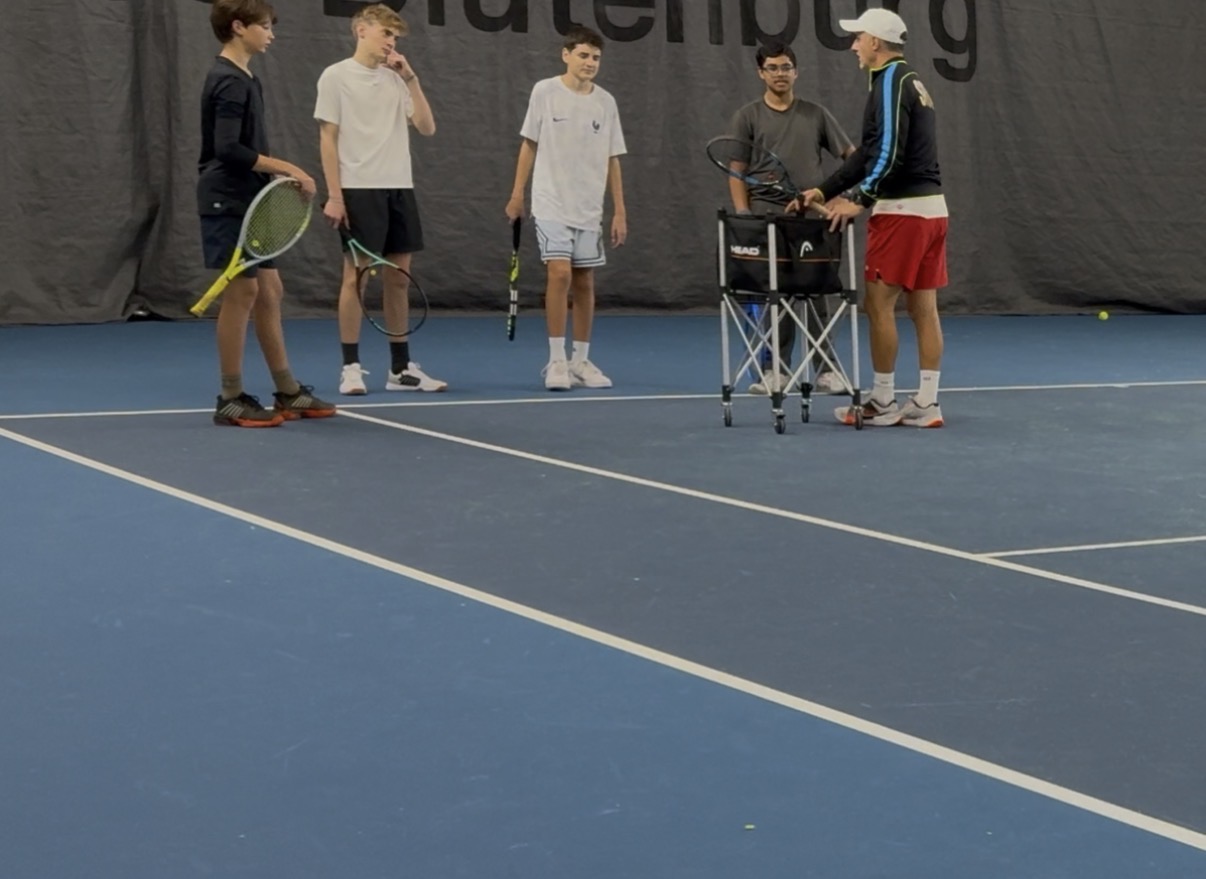 Trainer mit Jugendgruppe und Ballwagen in der Tennishalle TC Blutenburg