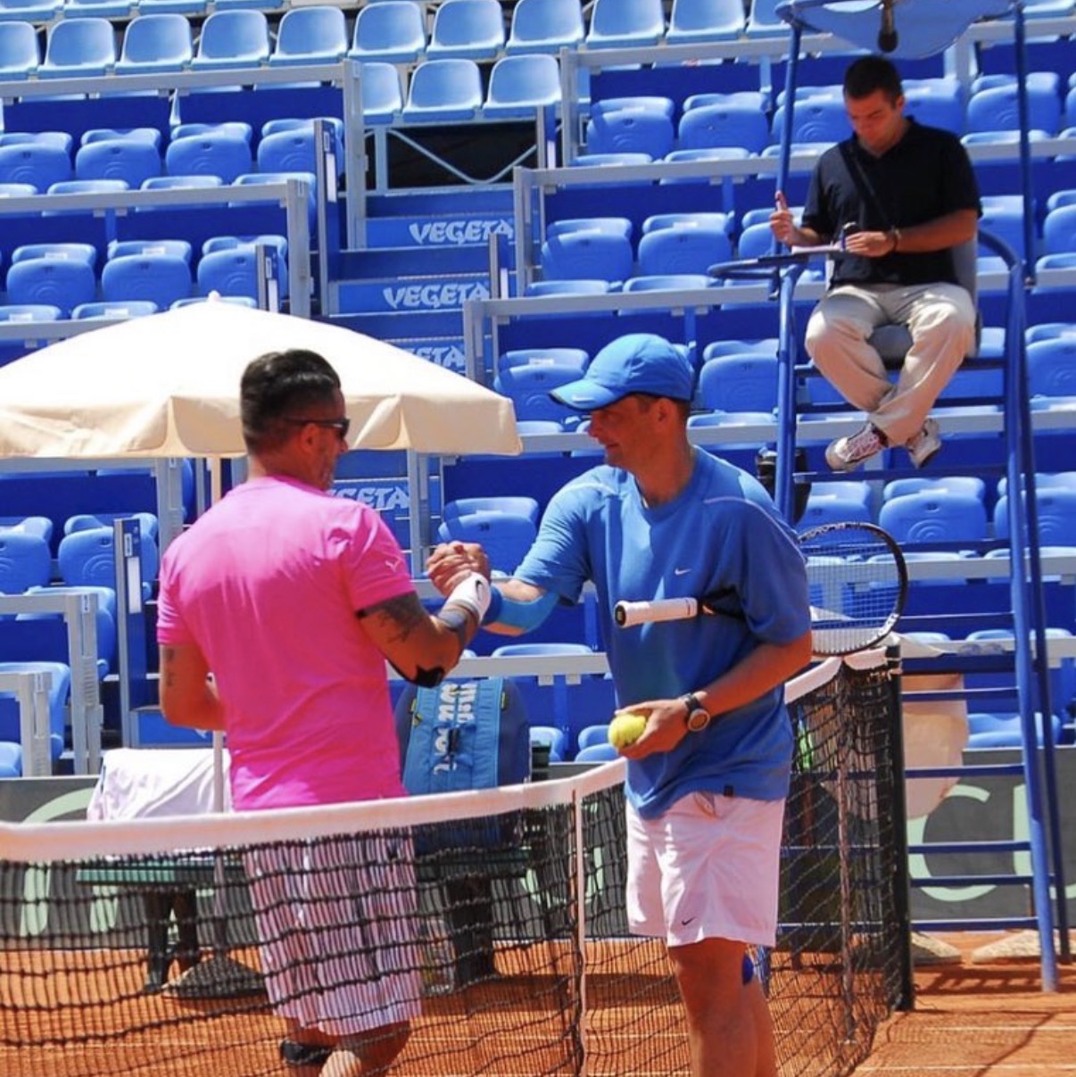 Trainer beim Handshake am Netz nach dem Match auf Sandplatz