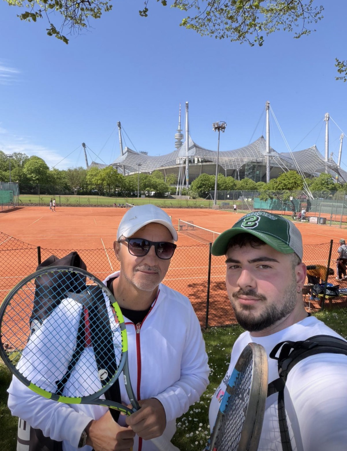Trainer mit Schüler auf Sandplatz vor dem Olympiastadion München