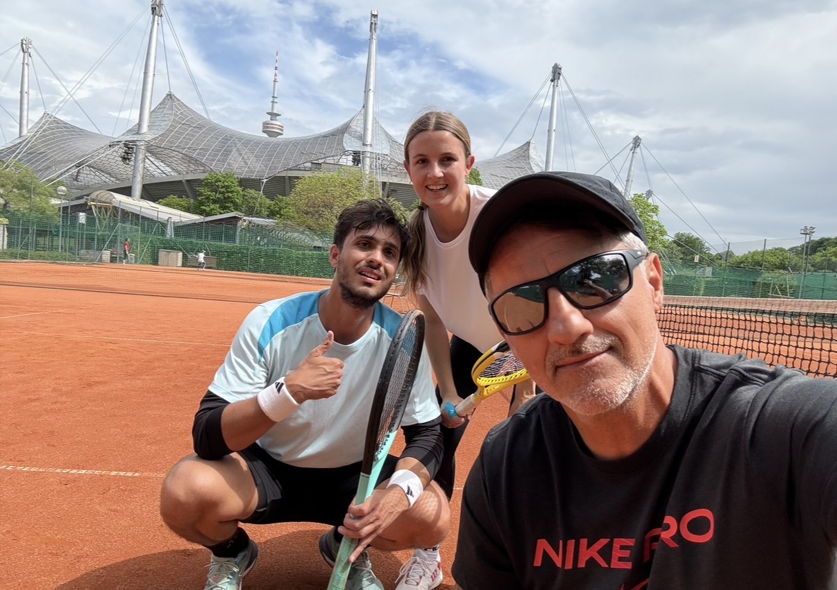 Trainer-Selfie mit zwei Spielern auf Sandplatz vor dem Olympiastadion München