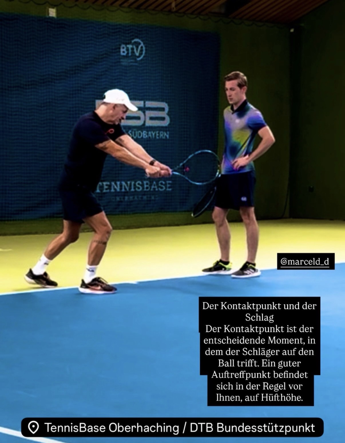 Trainer demonstriert Vorhand-Kontaktpunkt mit Schüler in der TennisBase Oberhaching