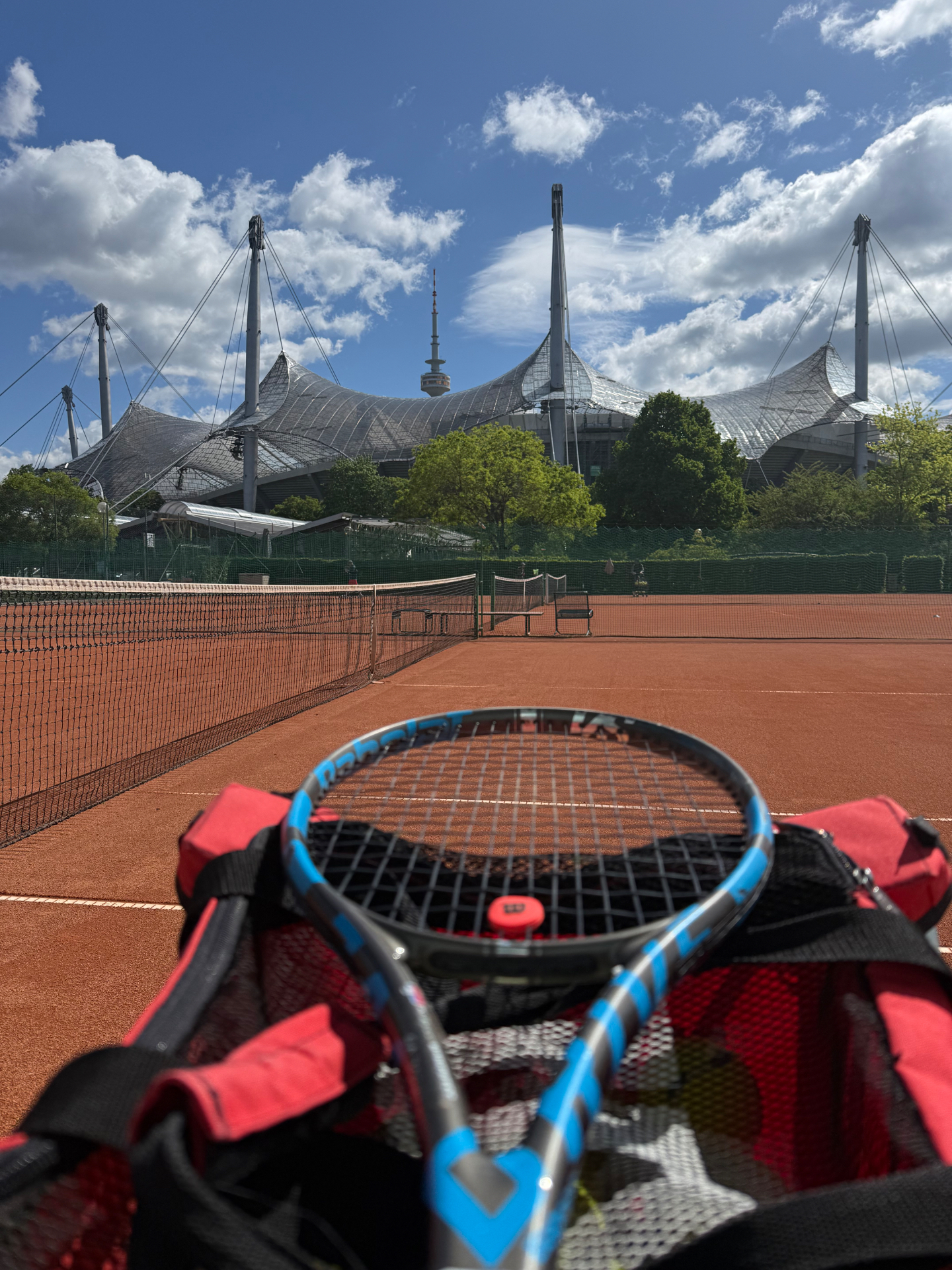 Sandplatz mit Blick auf das Münchner Olympiastadion