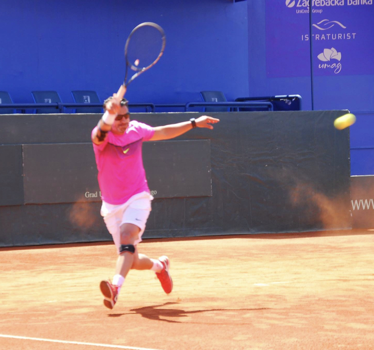 Spieler in pinkem Trikot beim Sprung-Aufschlag bei ATP Umag