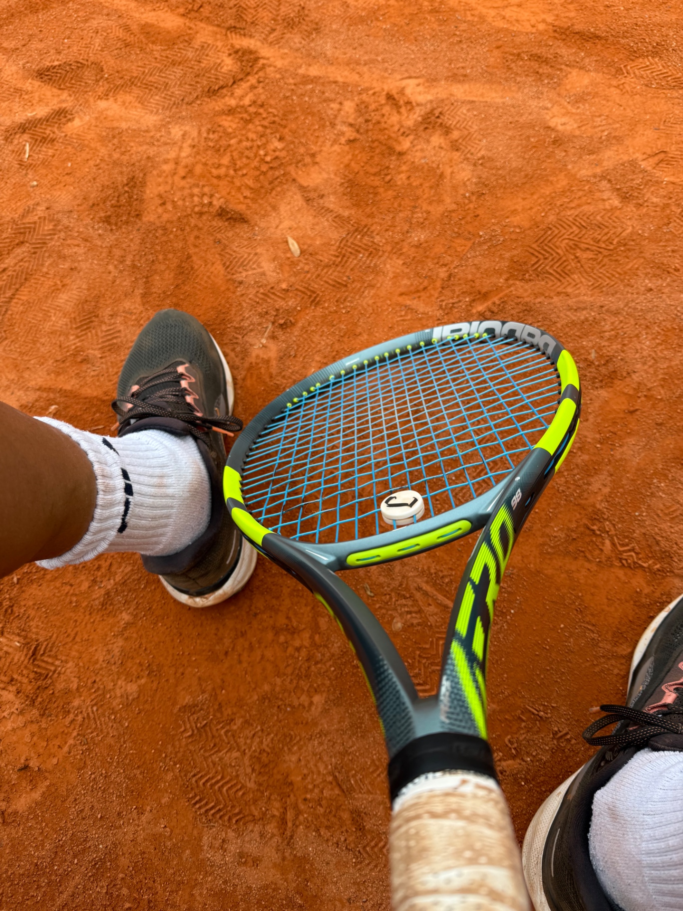 Babolat Schläger mit blauen Saiten auf Sandplatz, Top-Down-Ansicht